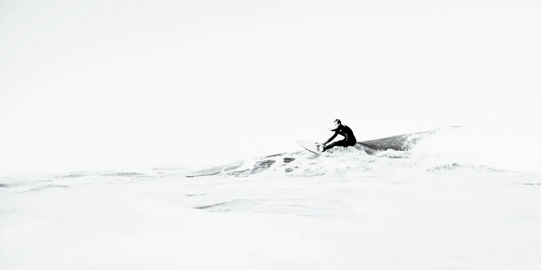 Black and white photograph of a surfer