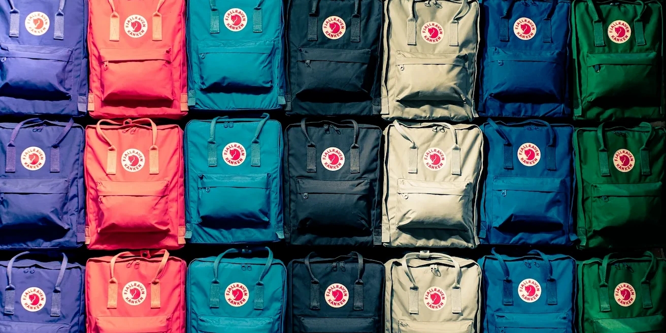 A series of backpacks in different colors and stacked together